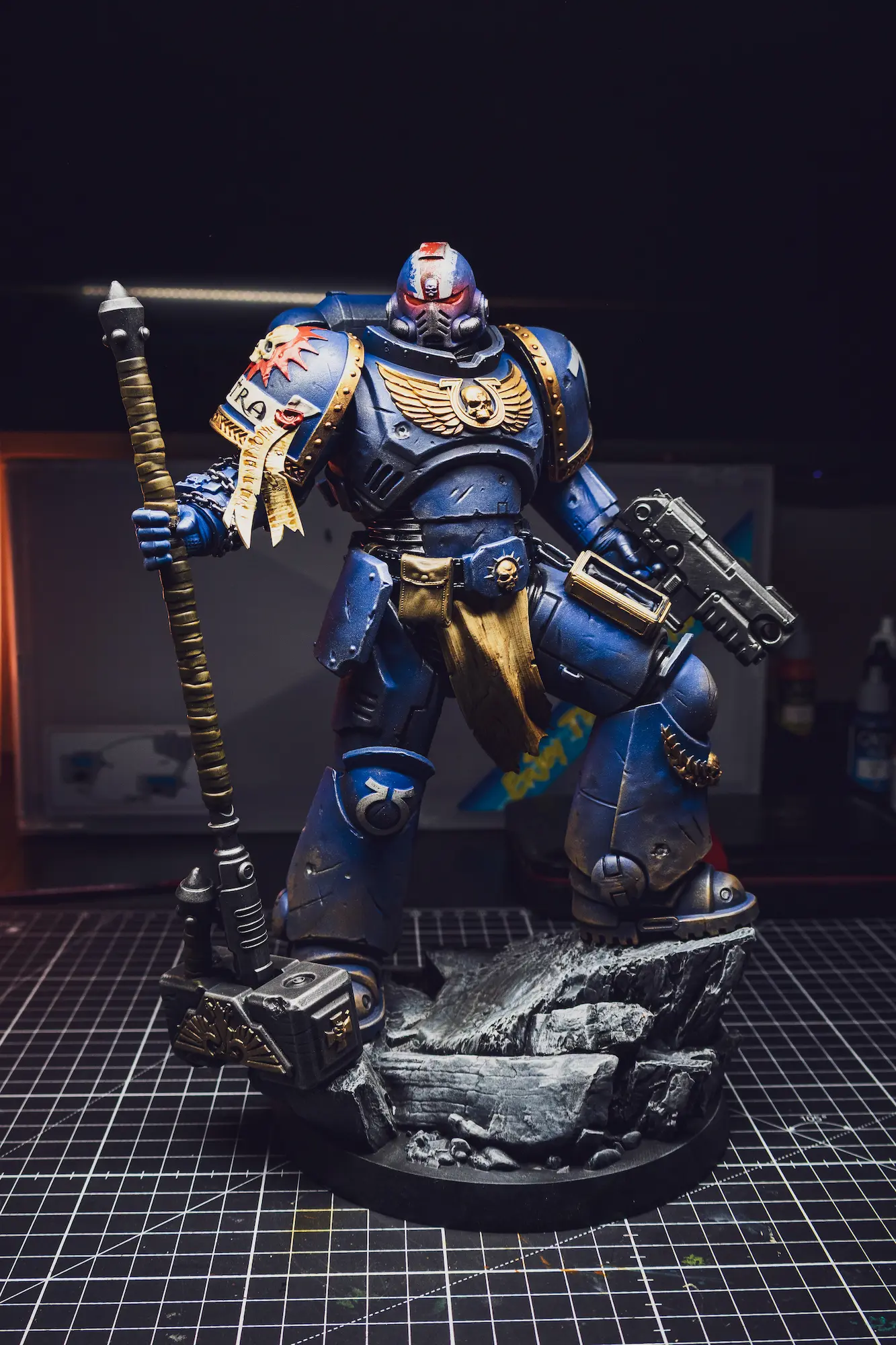 Space Marine miniature painted in deep blue power armor with battle-damage weathering.
